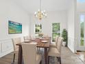 Elegant dining room featuring a chandelier, table set for six, and natural light at 12317 Panthersville Dr, Charlotte, NC 28269