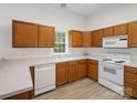 Bright kitchen featuring ample counter space, wood cabinets, and white appliances at 12317 Panthersville Dr, Charlotte, NC 28269