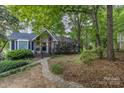 Quaint home with stone walkway and lush green trees surrounding the house at 1407 Jodhpur Ct, Charlotte, NC 28212
