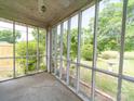 An inside view of the screened-in porch with views of the surrounding greenery and outdoor space at 1468 Hilltop St, Albemarle, NC 28001