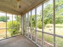 Inside view of the screened-in porch with views of the surrounding lush greenery and yard at 1468 Hilltop St, Albemarle, NC 28001