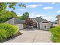 Charming home with a circular driveway, lush landscaping, and a three-car garage at 16108 Woolwine Rd, Charlotte, NC 28278