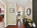 Hallway with hardwood floors, neutral walls, decorative art, and access to the living room at 17204 Caldwell Track Dr, Huntersville, NC 28078