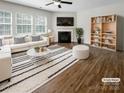 Cozy living room with a fireplace, large windows, modern furniture, and stylish decor at 1723 Loggerhead Dr, Lancaster, SC 29720
