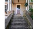 Inviting front entrance with stone stairs and pillars leading to the front door of the home at 208 N 5Th St, Albemarle, NC 28001