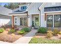 Inviting front entrance with an accent-colored door, trimmed with wood posts and lush green landscaping at 2396 Lee Lawing Rd, Lincolnton, NC 28092