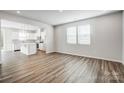Bright living space with luxury vinyl plank flooring adjoins a modern kitchen with an island at 2405 Hedgecliff Rd, Kannapolis, NC 28025
