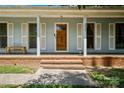 Close-up of the front entrance with a wooden door, white columns, and brick steps leading to the porch at 2635 Clover Hill Ln, Charlotte, NC 28215