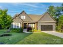 Attractive home with a well-manicured lawn, a two-car garage, and inviting front porch under a bright, sunny sky at 3424 Saint Clair Nw Ct, Concord, NC 28027
