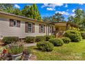 Close up view of charming home with flower garden and covered porch area at 3755 River Rd, Richfield, NC 28137