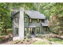 Two-story home with green siding, black trim, a white brick chimney and lovely front yard at 4316 Old Saybrook Ct, Charlotte, NC 28211