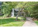 A charming home with green siding and a brick chimney surrounded by lush green trees at 4316 Old Saybrook Ct, Charlotte, NC 28211