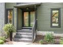 Close-up of a front entrance with a black framed glass door and brick stairs with decorative plants at 4316 Old Saybrook Ct, Charlotte, NC 28211