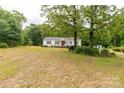 Single-story home with expansive yard and plenty of shade from mature trees at 439 Kershaw Country Club Rd, Kershaw, SC 29067