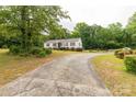 Ranch-style home with a long driveway surrounded by mature trees at 439 Kershaw Country Club Rd, Kershaw, SC 29067