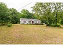 Quaint single-story home with a spacious front yard surrounded by mature trees at 439 Kershaw Country Club Rd, Kershaw, SC 29067