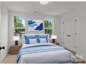 Bright bedroom with two windows, a bed with blue accents, and matching nightstands with lamps at 518 Herms Ave, Mount Holly, NC 28120