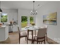Eat-in dining area with glass table, modern chandelier, stainless steel appliances, and sliding glass door at 518 Herms Ave, Mount Holly, NC 28120