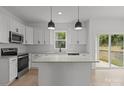 Modern kitchen with white cabinets, granite countertops, and stainless steel appliances at 518 Herms Ave, Mount Holly, NC 28120