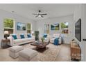 Bright living room with white furniture, hardwood floors, and natural light from large windows at 518 Herms Ave, Mount Holly, NC 28120