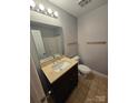 A bathroom featuring tile floors, a vanity sink with storage, and a shower with sliding door at 521 Donatello Ave, Charlotte, NC 28205