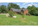 Beautiful brick home with an expansive front lawn and mature trees at 600 Old Hardin Rd, Dallas, NC 28034
