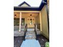 A close up of the covered porch showing classic lighting and brick steps leading to a glass front door at 603 Turnberry Ct, Albemarle, NC 28001
