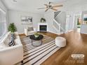 Bright living room featuring a fireplace, ceiling fan and modern furniture at 6457 Saint Bernard Way, Charlotte, NC 28269