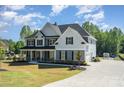 Beautiful home showcasing a large driveway and attached garage, surrounded by lush greenery and landscaping at 6814 Forney Hill Rd # 2, Denver, NC 28037