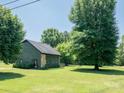 Home with a well-manicured lawn, stone facade, and sunroom, perfect for relaxation and enjoyment at 7728 Babe Stillwell Farm Rd, Huntersville, NC 28078