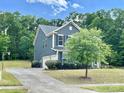 Side view of a two-story home showing the driveway and landscaping at 8268 Breton Way, Harrisburg, NC 28075
