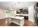 Kitchen featuring a large island with quartz countertops, dark cabinets, and stainless steel appliances at 8268 Breton Way, Harrisburg, NC 28075