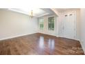 Bright living room featuring hardwood floors, modern lighting, and large windows at 8268 Breton Way, Harrisburg, NC 28075