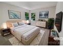 Stylishly staged main bedroom featuring a comfortable bed, soft lighting, and serene wall art at 9116 Torrence Creek Ct, Huntersville, NC 28078