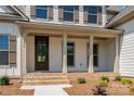 Inviting front porch with brick accents, stately columns, and a beautiful dark wooden door at 104. Wilharr Ct # 40, Mooresville, NC 28115