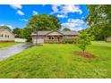 Inviting single-story home with a well-manicured lawn, mature trees, and attached garage at 117 Ethel Ln, Statesville, NC 28625