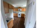 Bright kitchen features wood cabinets, white appliances, and wood-look floors at 118 Steam Engine Dr # 201, Mooresville, NC 28115