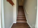 A well-lit staircase with hardwood steps and a coat rack for a welcoming entrance at 118 Steam Engine Dr # 201, Mooresville, NC 28115