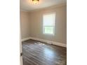 Small bedroom features wood-look flooring, neutral paint, and a bright window at 1336 Norris Ave, Charlotte, NC 28206