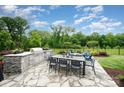 Outdoor kitchen features stone accents, built in grill, dining area, and comfortable seating at 13602 Huntson Park Ln, Huntersville, NC 28078