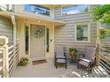 Inviting covered front porch with seating, plants and a 'Stay Awhile' door mat at 14118 Yachtsman Harbor Dr, Charlotte, NC 28278