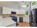 Bright kitchen featuring white cabinets, stainless steel appliances, tiled floors and a large window at 14118 Yachtsman Harbor Dr, Charlotte, NC 28278