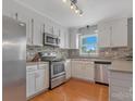 Well-lit kitchen featuring stainless steel appliances, light countertops, and white cabinets at 195 Antler Dr, Statesville, NC 28625