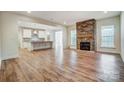 Open-concept living room with a stone fireplace and hardwood floors, connecting to the kitchen at 206 Streamwood Rd # 32, Troutman, NC 28166