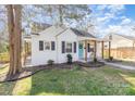 Charming white brick home featuring a cozy front porch and landscaped yard at 3141 Mathis Dr, Charlotte, NC 28208