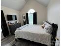 Comfortable bedroom featuring a vaulted ceiling and a large arched window at 334 River Birch Cir, Mooresville, NC 28115