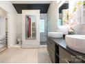 Contemporary bathroom showcasing dual sinks, tiled shower, and decorative accents at 3626 Cole Mill Rd, Charlotte, NC 28270