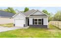 Charming one-story home with light gray siding, black shutters, and a one-car garage at 401 Groves St, Lowell, NC 28098