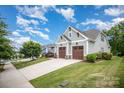 Attractive home featuring a well-kept lawn, two-car garage, and charming exterior details under a bright blue sky at 4016 Spring Cove Way, Belmont, NC 28012