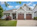 Inviting home showcasing a two-car garage, green lawn, and appealing facade with craftsman details at 4016 Spring Cove Way, Belmont, NC 28012